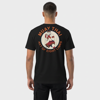 T-shirt unisexe vu de dos, avec un écusson vintage montrant un combattant de Muay Thaï en garde, aux mains bandées de rouge, dans un médaillon crème entouré du texte « Muay Thai – Art of Eight Limbs ». – photo studio