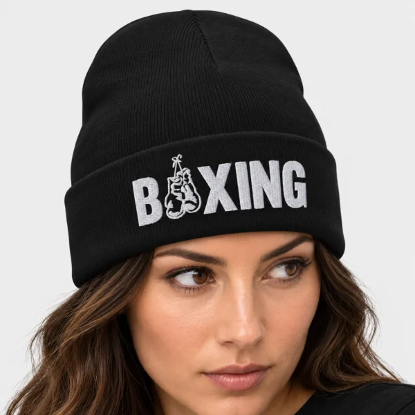 Bonnet en maille avec la broderie « BOXING » sur le devant, dont le « O » est remplacé par une paire de gants de boxe suspendus. – photo studio femme
