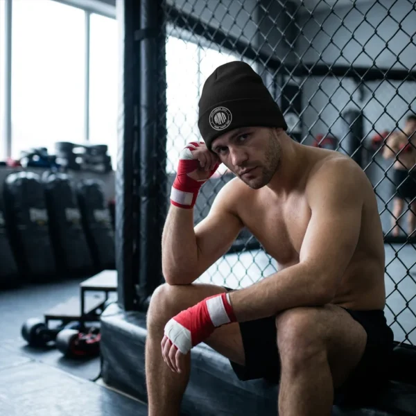 Bonnet ajusté avec, brodé sur le devant, un badge circulaire « MMA » en rayures façon code-barres, entouré des mots « Mixed Martial Arts » et « Strike · Grapple · Fight ».