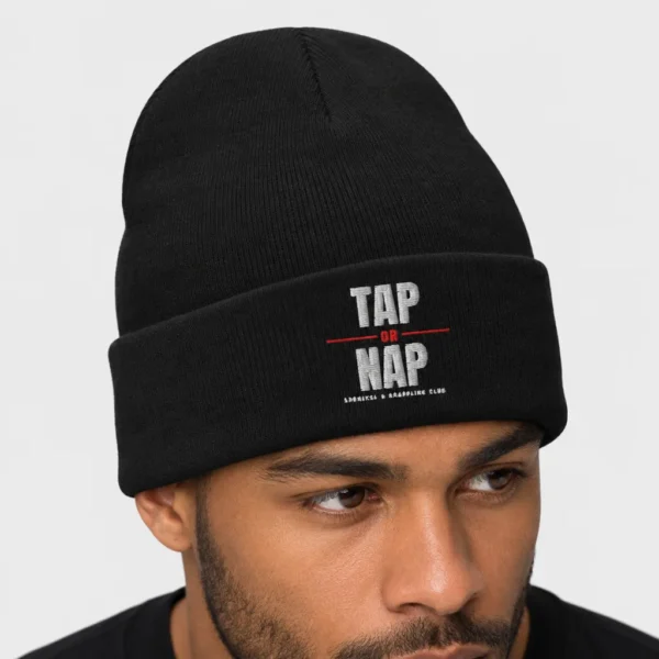 Bonnet en maille brodé sur le devant du slogan « TAP OR NAP » en lettres noires avec un « OR » rouge et la mention « SUBMISSION GRAPPLING CLUB ». – photo studio