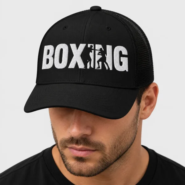 Casquette trucker rétro brodée sur le devant du mot BOXING en lettres noires, dont le I et le N sont découpés par les silhouettes de deux boxeurs en plein échange. – photo studio