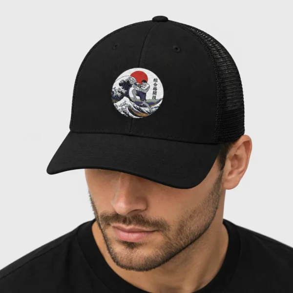 Casquette trucker rétro avec, brodé sur le devant, un médaillon façon estampe japonaise montrant un combattant de MMA au genou volant qui surgit de la Grande Vague de Kanagawa devant un soleil rouge. – photo studio