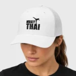 Casquette trucker rétro brodée sur le devant d'une silhouette noire de combattant de muay-thaï en high kick, au-dessus de l'inscription « MUAY THAI » à effet craquelé. – photo studio femme Casquette trucker rétro brodée sur le devant d'une silhouette noire de combattant de muay-thaï en high kick, au-dessus de l'inscription « MUAY THAI » à effet craquelé. – photo studio femme