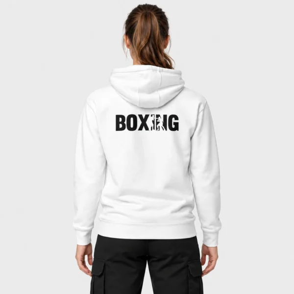 Hoodie unisexe avec, imprimé au dos, le mot « BOXING » en lettres noires où le I et le N laissent apparaître en négatif deux boxeurs en plein échange de coups. – photo studio femme