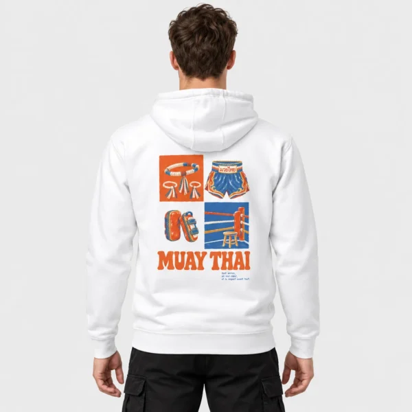 Sweat à capuche clair imprimé d'une illustration vintage de mongkol, short thaï, paos et coin de ring au-dessus du titre orange « MUAY THAI ». – photo studio
