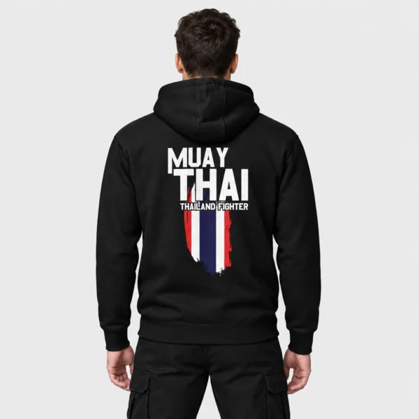 Hoodie avec au dos l'inscription « MUAY THAI » en grandes lettres blanches sur un drapeau thaïlandais vertical peint au pinceau et le sous-titre « THAILAND FIGHTER ». – photo studio
