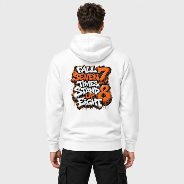Sweat à capuche unisexe avec, imprimée au dos, la citation « Fall Seven Times Stand Up Eight » en lettrage graffiti orange et blanc, avec coulures et éclaboussures de peinture. – photo studio