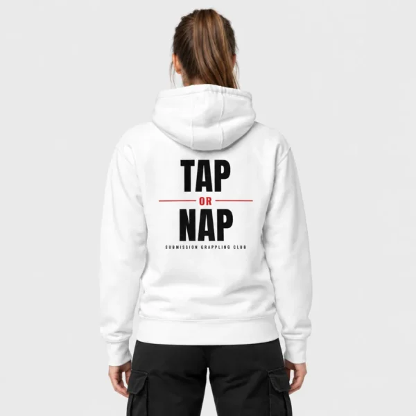 Hoodie unisexe avec l'inscription « TAP OR NAP » en lettres noires texturées imprimée dans le dos, un « OR » rouge entre deux lignes rouges et la mention « SUBMISSION GRAPPLING CLUB » en dessous. – photo studio femme