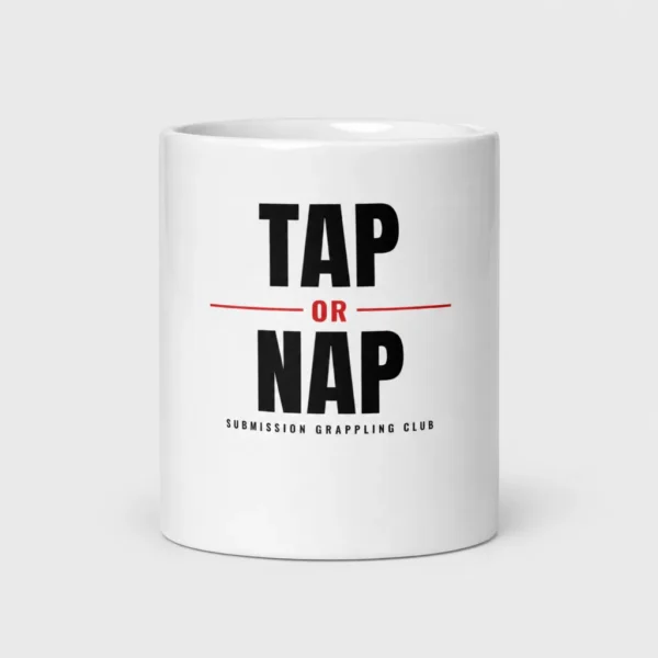 Mug blanc brillant imprimé du slogan « TAP OR NAP » en lettres noires texturées avec un « OR » rouge et la mention « SUBMISSION GRAPPLING CLUB ». – photo studio