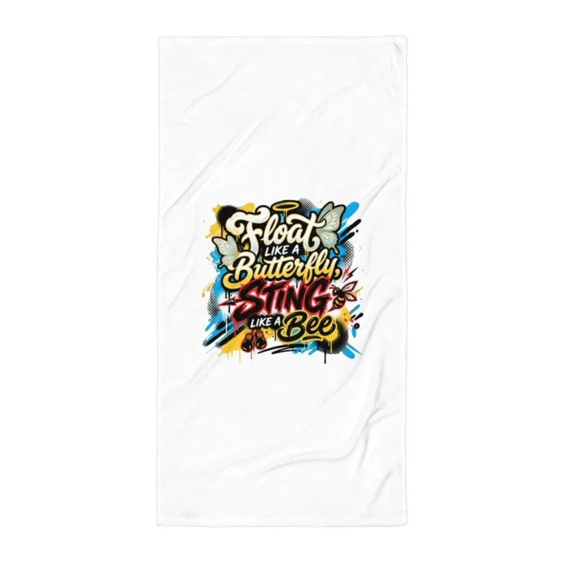 Serviette de plage blanche imprimée de la citation de boxe « Float like a Butterfly, Sting like a Bee » en lettrage graffiti, avec papillons, abeille, auréole et gants de boxe sur fond d'éclaboussures jaunes, bleues et noires. (Blanc, mockup principal)