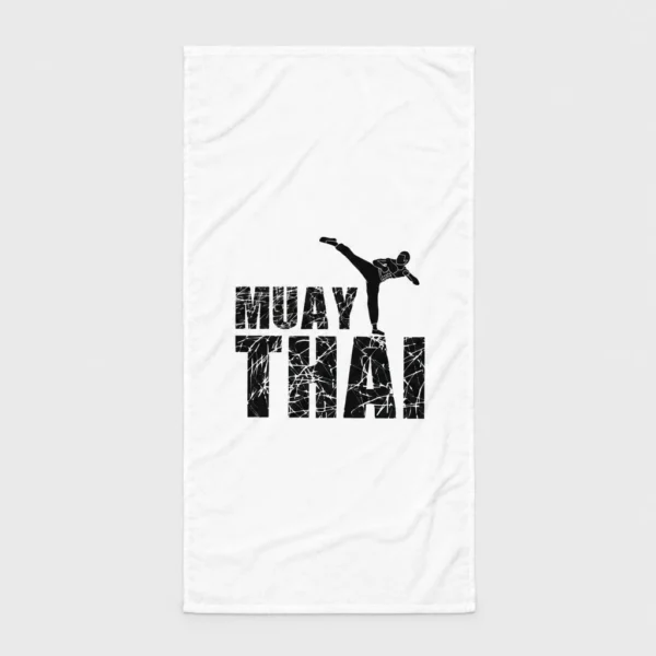 Serviette de plage blanche imprimée de la silhouette noire d'un combattant de muay-thaï en high kick au-dessus des lettres « MUAY THAI » à effet craquelé. – photo studio