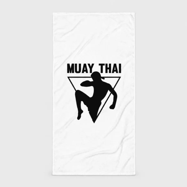 Serviette de plage blanche avec la silhouette noire d'un combattant de muay-thaï portant un mongkol et donnant un coup de genou sauté devant un triangle inversé, sous le titre « MUAY THAI ». – photo studio