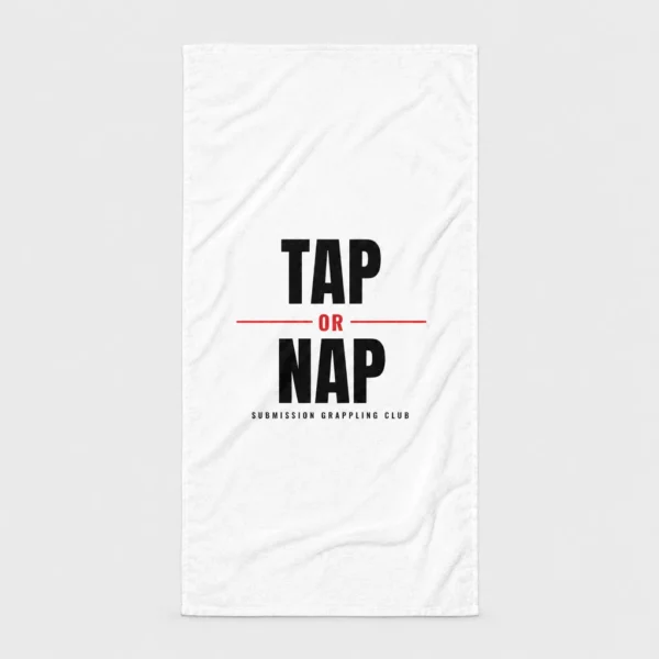 Serviette de plage blanche imprimée du slogan « TAP OR NAP » en lettres noires texturées avec un « OR » rouge et la mention « SUBMISSION GRAPPLING CLUB ». – photo studio