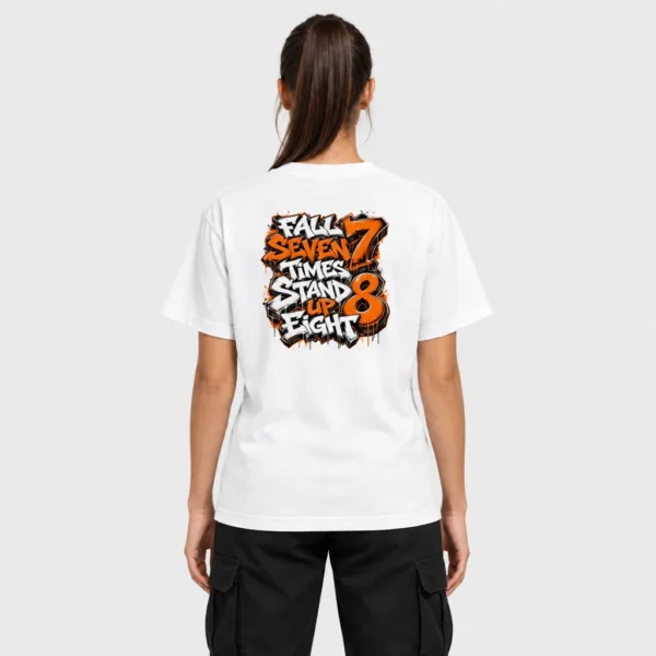 T-shirt unisexe vu de dos avec la citation « Fall Seven Times Stand Up Eight » en lettrage graffiti blanc et orange, grands chiffres 7 et 8, coulures et éclaboussures noires et orange. – photo studio femme