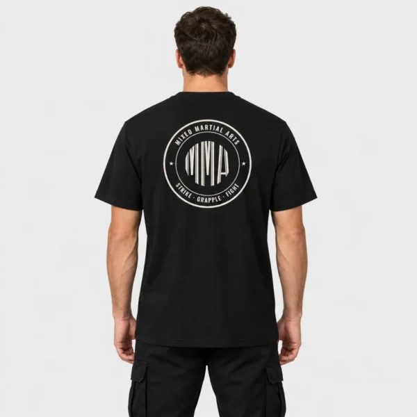 T-shirt unisexe vu de dos, imprimé d'un badge circulaire MMA avec lettres façon code-barres et inscriptions « Mixed Martial Arts » et « Strike · Grapple · Fight ». – photo studio