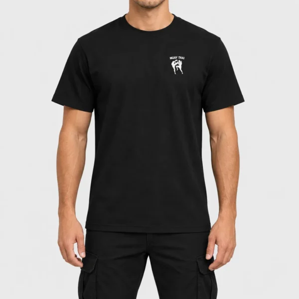 T-shirt unisexe en coton bio avec, côté cœur, deux silhouettes noires de combattants de muay-thaï en plein échange (high kick et blocage du genou) sous le texte « MUAY THAI ». – photo studio