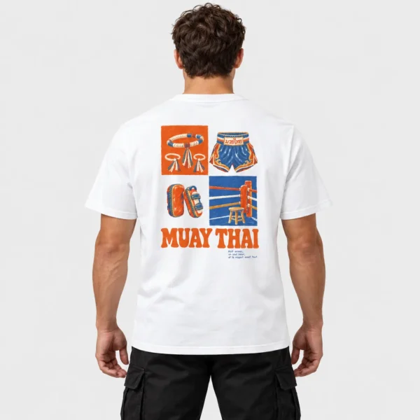 T-shirt unisexe avec une illustration vintage orange et bleue du mongkol, du short thaï, des paos et d'un coin de ring au-dessus du titre « MUAY THAI ». – photo studio