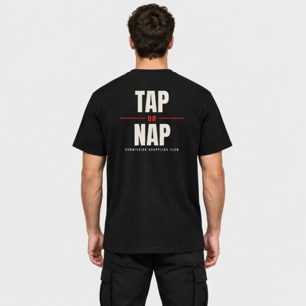 T-shirt unisexe vu de dos, imprimé du slogan « TAP OR NAP » en lettres noires texturées avec un « OR » rouge et la mention « SUBMISSION GRAPPLING CLUB ». – photo studio